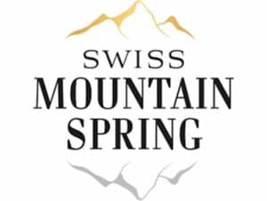 Logo avec des sommets de montagne stylisés en or et en argent au-dessus du texte "Swiss Mountain Spring". Les lettres noires vives suggèrent une marque rafraîchissante et naturelle, engagée dans le développement durable.